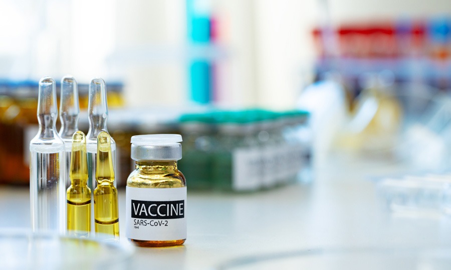 Vaccine in vial for injection on table against background of laboratory